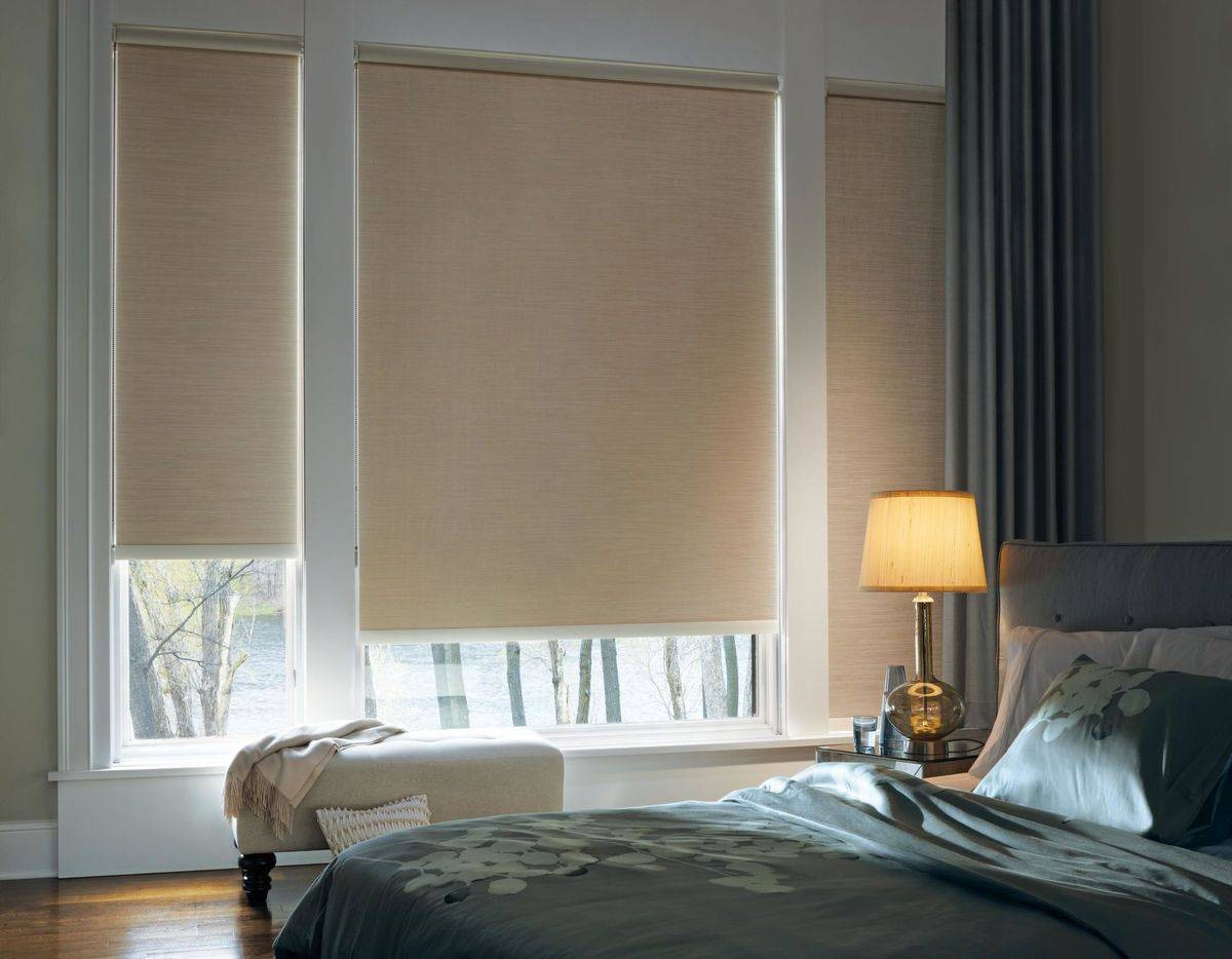 Cozy and modern bedroom decorated with tan Hunter Douglas Designer Roller Shades