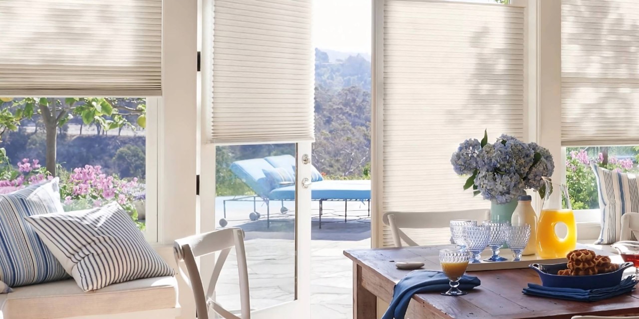 Hunter Douglas Duette® Cellular Shades on windows and a patio door in a coastal living room at Enhancement Window Design near Boynton Beach, FL
