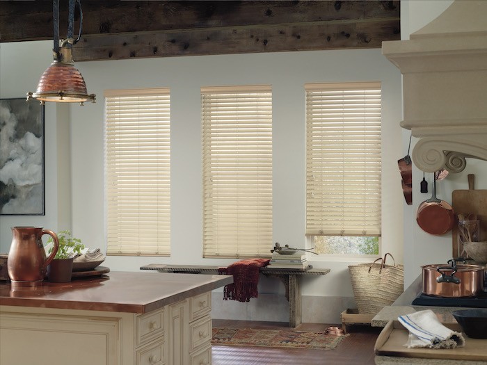 A kitchen with copper countertop, lamp and pots. 